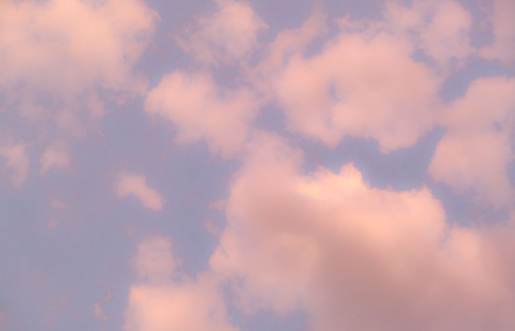 Captivating image of gentle pink clouds floating in a tranquil blue sky.